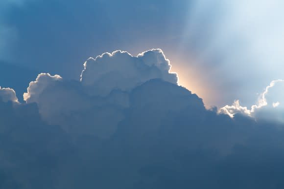 Rays of light emanating from behind a cloud.