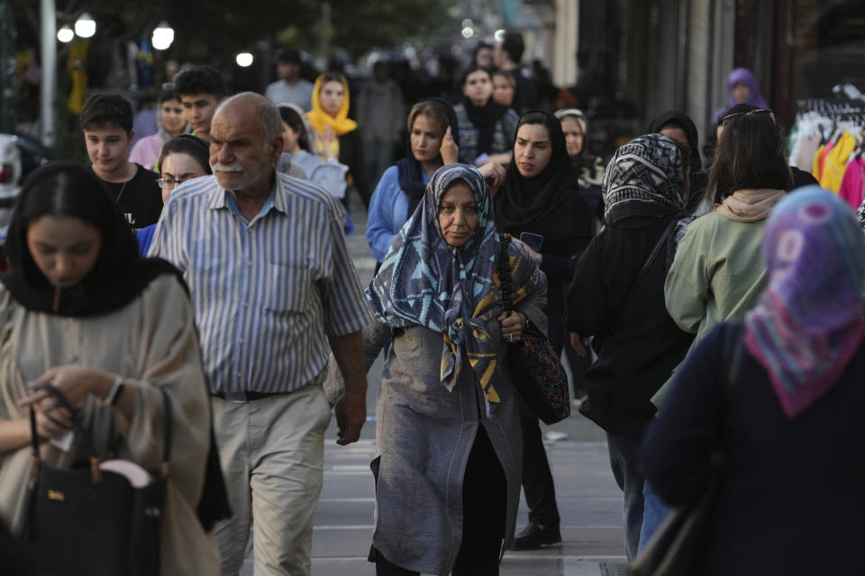 People walk in downtown Tehran, Iran, Saturday, Sept. 9, 2023. Iranians are marking the first anniversary of nationwide protests over the country's mandatory headscarf law that erupted after the death of a young woman detained by morality police. (AP Photo/Vahid Salemi)
