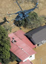 Stranded residents are rescued by a helicopter as the town is flooded by typhoon Hagibis, in Marumori, Miyagi prefecture, northern Japan, Sunday, Oct. 13, 2019. Rescue efforts for people stranded in flooded areas are in full force after a powerful typhoon dashed heavy rainfall and winds through a widespread area of Japan, including Tokyo.(Kyodo News via AP)