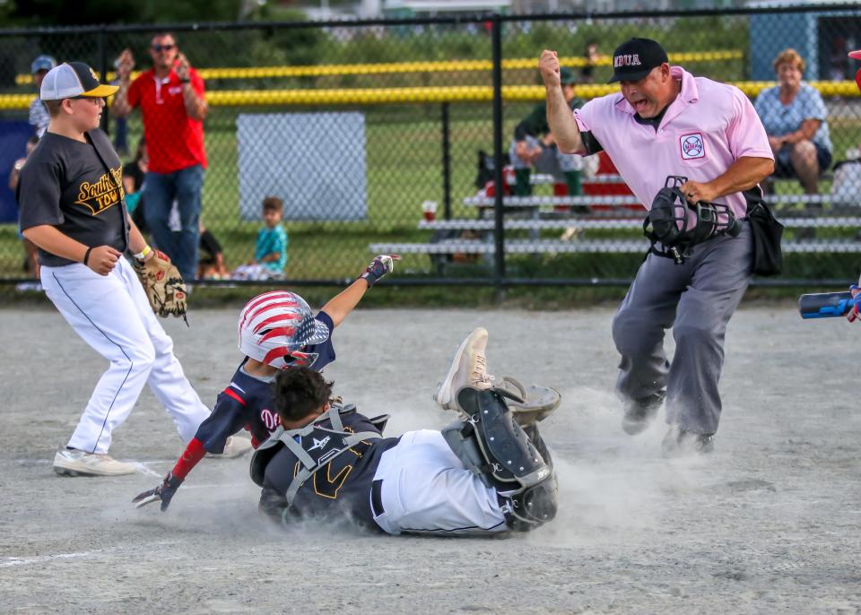 Austin Rodrigues of DeBross Oil is tagged out at home on a diving tag by Jose Martinez of South Coast Towing. Rodrigues was attempting to score on a delayed steal. Umpire Anthony Poente makes the call on the play.