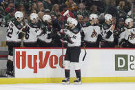 Arizona Coyotes defenseman J.J. Moser (90) is congratulated for his goal against the Minnesota Wild during the third period of an NHL hockey game Sunday, Nov. 27, 2022, in St. Paul, Minn. (AP Photo/Stacy Bengs)