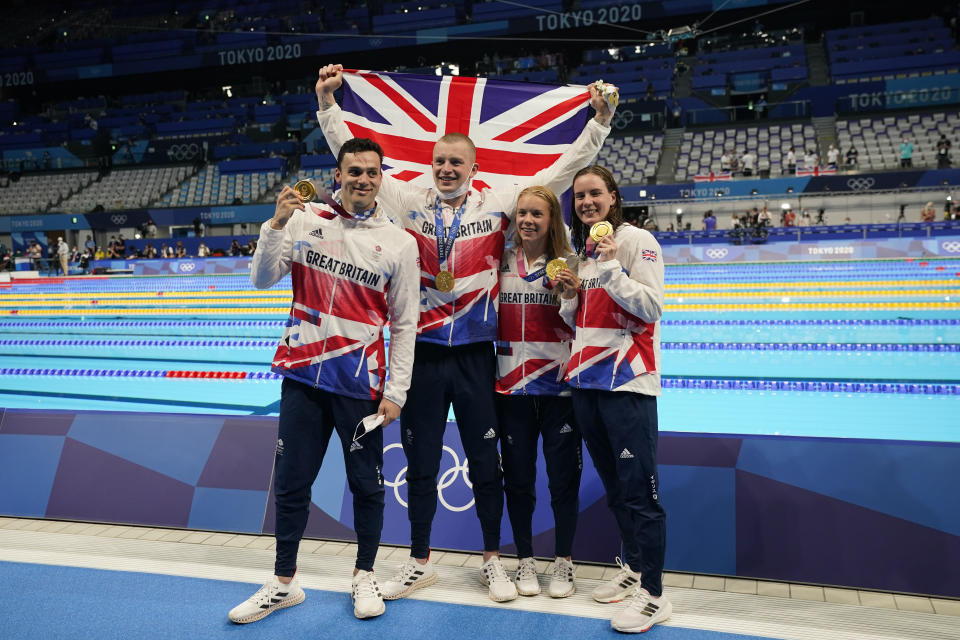 Britain's mixed 4x100-meter medley relay team, Kathleen Dawson, Adam Peaty, James Guy and Anna Hopkin, poses after winning the gold medal at the 2020 Summer Olympics, Saturday, July 31, 2021, in Tokyo, Japan.(AP Photo/Jae C. Hong)