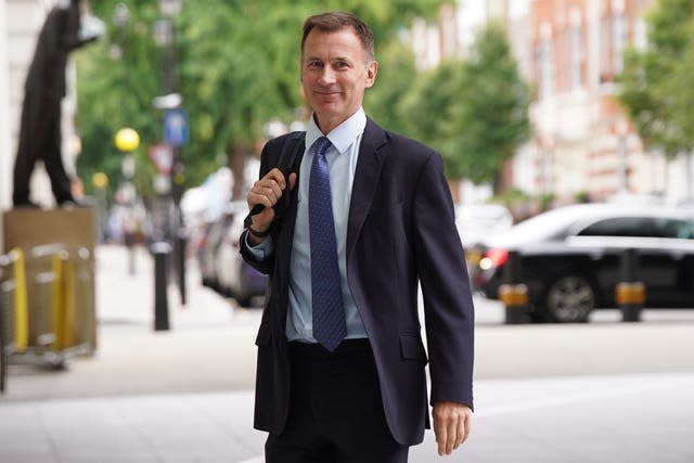 Jeremy Hunt, backpack over his right shoulder, smiles as he arrives at the BBC's Broadcasting House for an appearance with Laura Kuenssberg on Sunday.