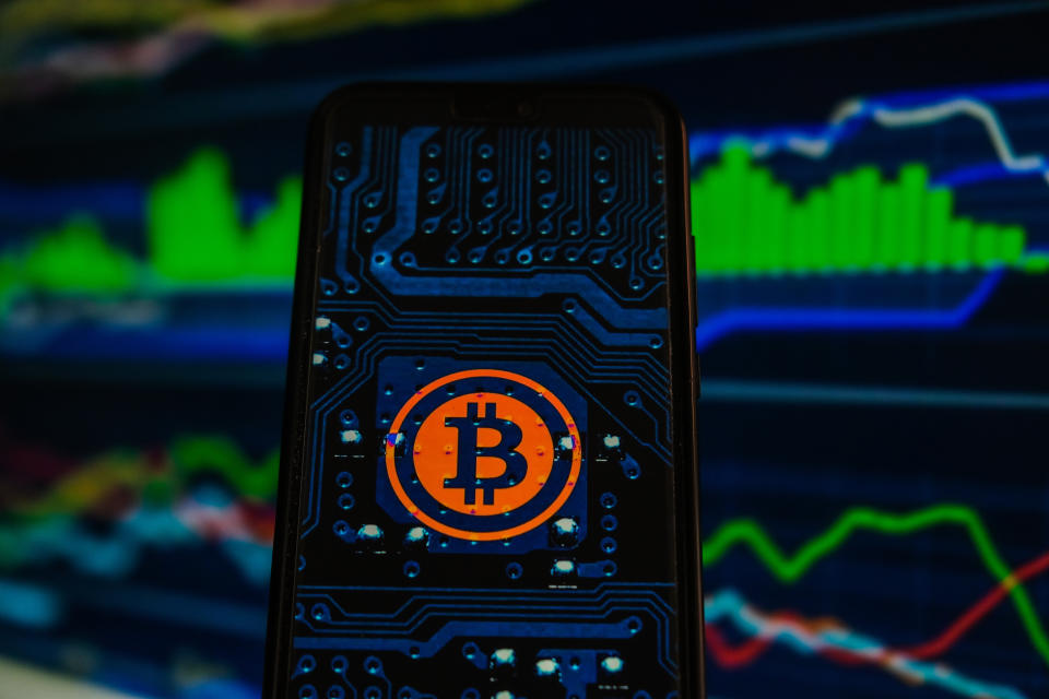 POLAND - 2021/06/02: In this photo illustration a Bitcoin logo is displayed on a smartphone with stock market percentages in the background. (Photo Illustration by Omar Marques/SOPA Images/LightRocket via Getty Images)