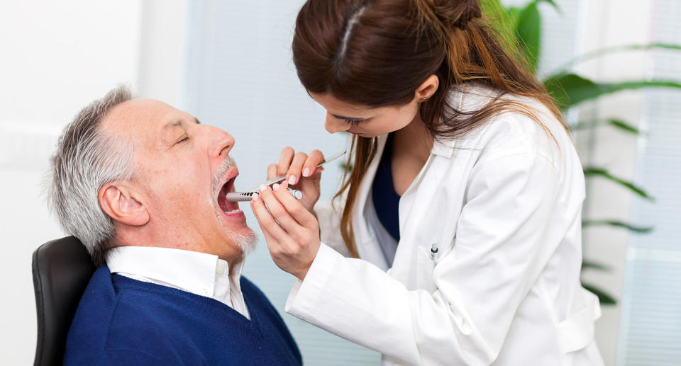 Doctor examining man for mouth cancer. (Getty Images)