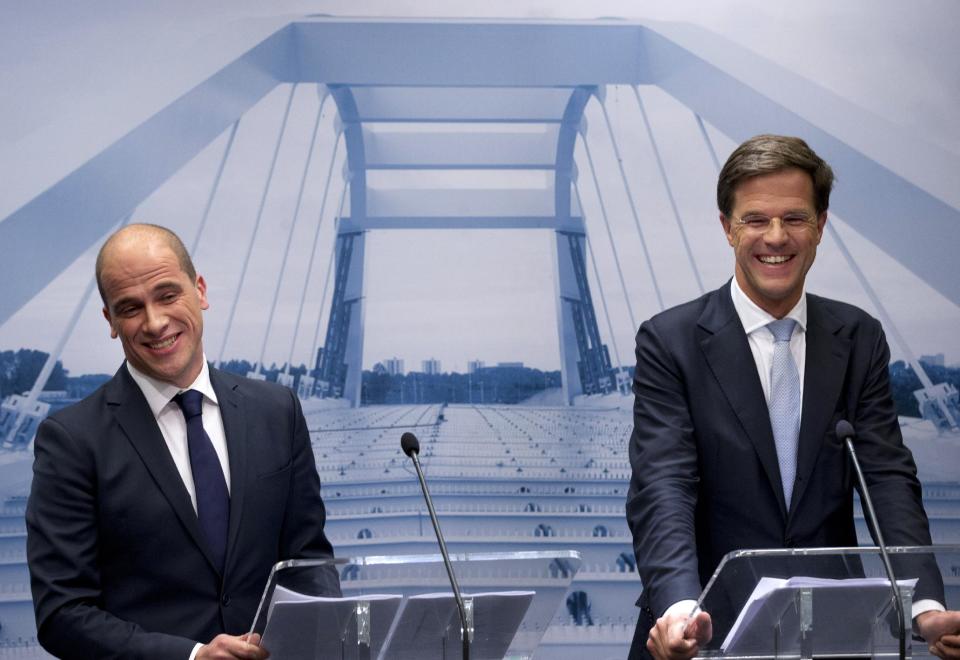 Caretaker Prime Minister Mark Rutte, right, and Labor Party Leader Diederik Samsom, left, smile in front of a picture symbolizing the theme of the new government, "building bridges", during a joint press conference in The Hague, Netherlands, Monday Oct. 29, 2012. The Netherlands is close to getting a new coalition government after lawmakers from the two biggest parties approved a policy deal hammered out by their leaders. Rutte, leader of the pro-free market VVD party, and center-left Labor Party chief Samsom have been negotiating behind closed doors for weeks to resolve policies for their proposed coalition. (AP Photo/Peter Dejong)