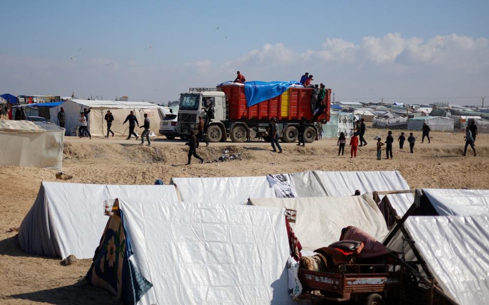 A truck carrying aid arrives at a refugee camp near the border with Egypt in Rafah