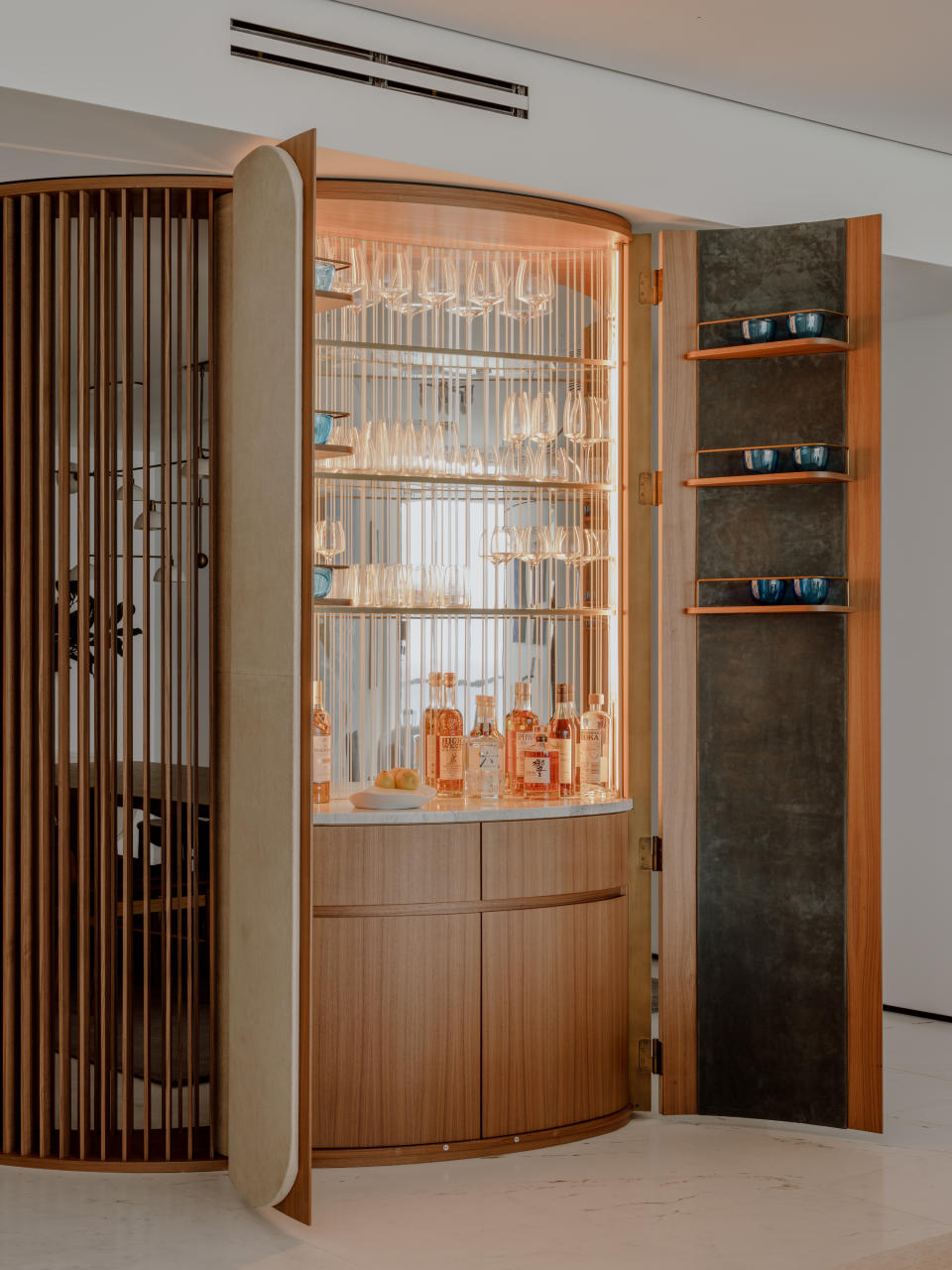 A bar cabinet hidden inside a wooden wall