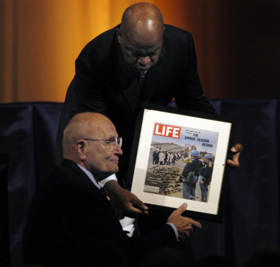 Rep. John Lewis (D-Ga.) presents Dingell with&nbsp;a signed magazine showing a&nbsp;famed civil rights march during&nbsp;Dingell's 50th anniversary party in the National Building Museum in 2005.