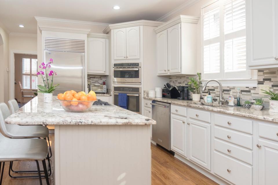 The kitchen has new countertops and stainless steel appliances. It also has extra seating with the addition of some comfortable stools.