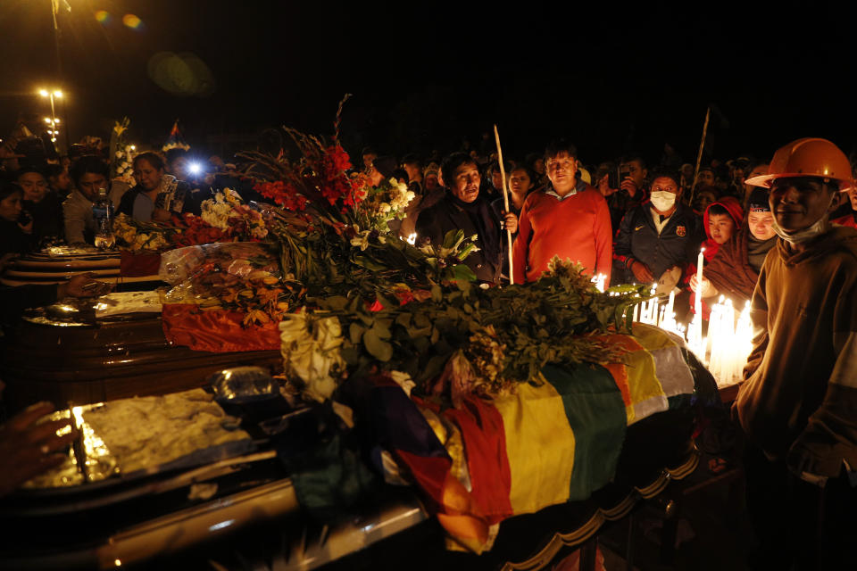 Mourners gather around coffins of backers of former President Evo Morales killed during clashes with security forces in Sacaba, Bolivia, Friday, Nov. 15, 2019. Bolivian security forces clashed with Morales' backers leaving at least five people dead, dozens more injured and escalating the challenge to the country's interim government to restore stability. (AP Photo/Juan Karita)