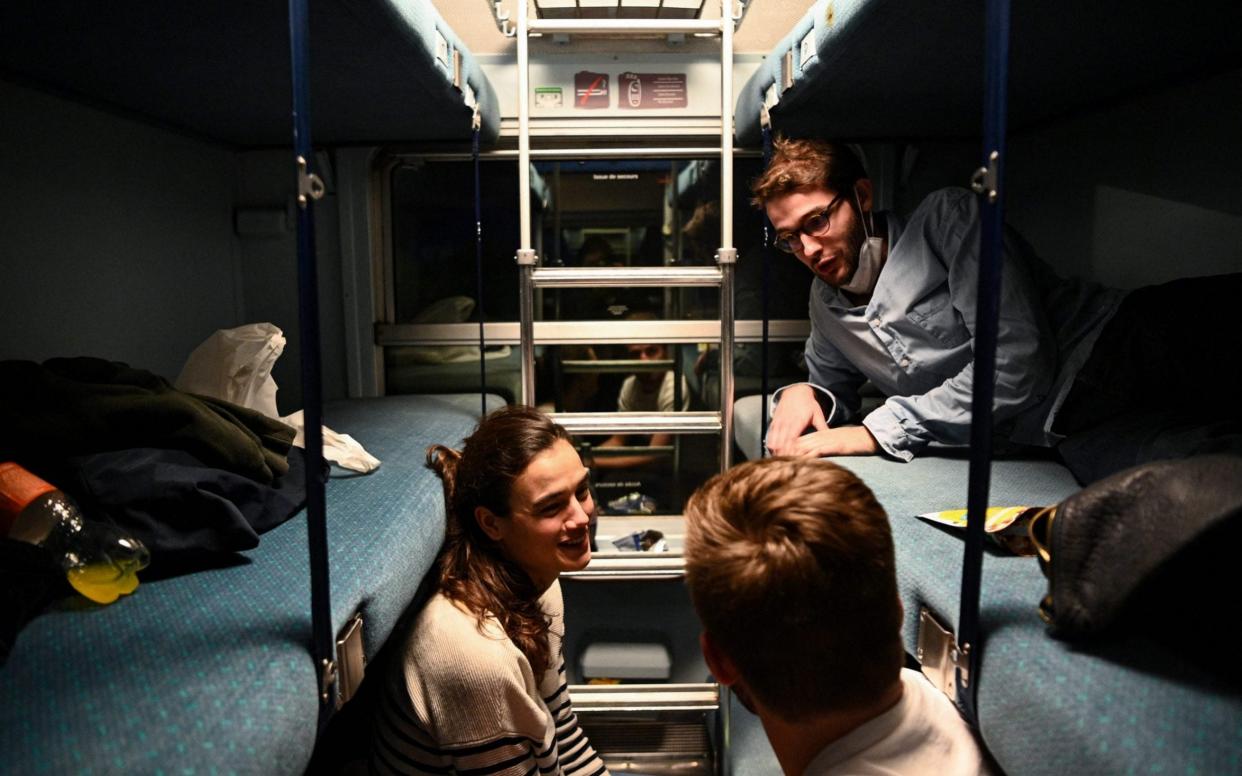 three friends sat in carriage on train - ANNE-CHRISTINE POUJOULAT /AFP