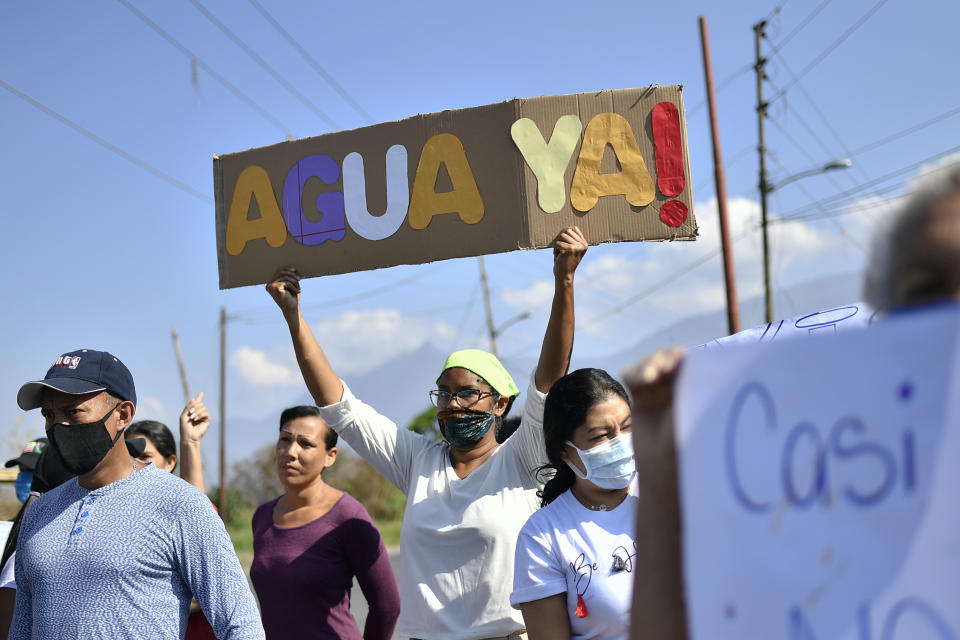 La Lira neighborhood residents protest the lack of public services including water, in Caracas, Venezuela, Thursday, May 21, 2020. An estimated 86% of Venezuelans reported unreliable water service, including 11% who have none at all, according to an April survey by the non-profit Venezuelan Observatory of Public Services. (AP Photo/Matias Delacroix)