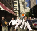 <p>People run from the collapse of World Trade Center on Fulton Street on Sept. 11, 2001. (Photo: Suzanne Plunkett/AP) </p>