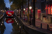 A red heart carries a social distancing message in a near-empty Red Light District in Amsterdam, Netherlands, Friday, Oct. 23, 2020. (AP Photo/Peter Dejong)