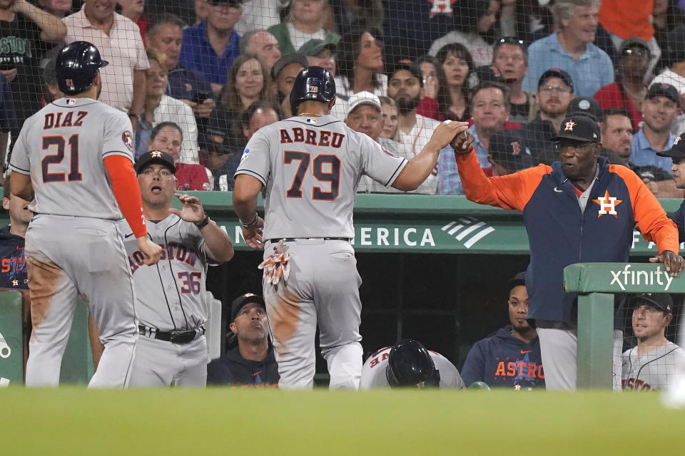 Houston Astros' Yainer Diaz (21) and Jose Abreu (79) are welcomed to the dugout after scoring on a double by Mauricio Dubon during the sixth inning of the team's baseball game against the Boston Red Sox, Tuesday, Aug. 29, 2023, in Boston. (AP Photo/Steven Senne)
