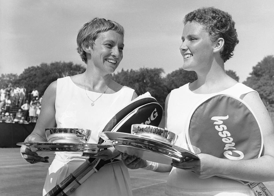 FILE - Darlene Hard, left, of the United States, and partner Lesley Turner, of Australia, pose for photos after winning the women's U.S. Lawn Tennis Association women's doubles championship at Longwood Cricket Club in Brookline, Mass., Aug. 28, 1961. Hard, an aggressive serve-and-volley player who won three major singles titles as well as 18 major doubles titles in a Hall of Fame tennis career, died Thursday, Dec. 2, 2021, after a brief illness. She was 85. (AP Photo/Bill Chaplis, File)