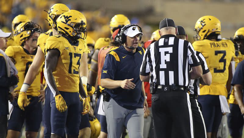 West Virginia coach Neal Brown, center, speaks with an official during game against Kansas in Morgantown, W.Va., Saturday, Sept. 10, 2022. The Mountaineers have been mediocre at best during Brown’s time at the helm. What happens in 2023 could well make or break things for him in Morgantown.