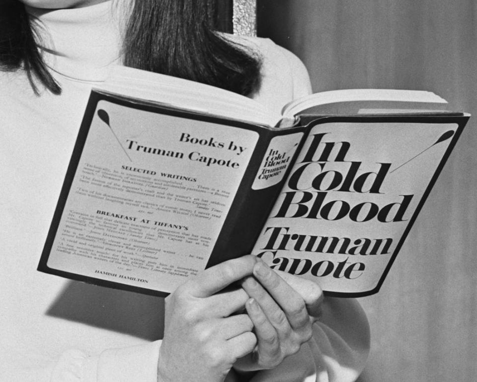 A woman holding the Truman Capote book 'In Cold Blood'