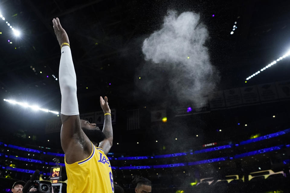El jugador de los Lakers de Los Ángeles LeBron James lanza pólvora al aire antes del 4to juego de su semifinal de la Conferencia Oeste de la NBA contra los Warriors de Golden State, el lunes 8 de mayo de 2023 en Los Ángeles. (AP Foto/Marcio Jose Sanchez)