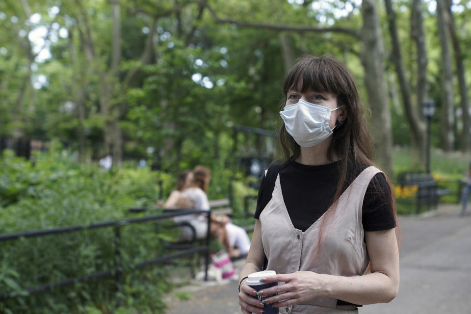 In this June 22, 2020 photo, Marissa Oliver, a COVID-19 survivor who found comfort discussing her experience with the virus and fear of death at Death Cafe meetups, walks through a park in her neighborhood in the Brooklyn borough of New York. Others attending virtual Death Cafes, part of a broader "death-positive" movement to encourage more open discussion about grief, trauma and loss, are coping with deaths from COVID-19, cancer and other illnesses. (AP Photo/Emily Leshner)