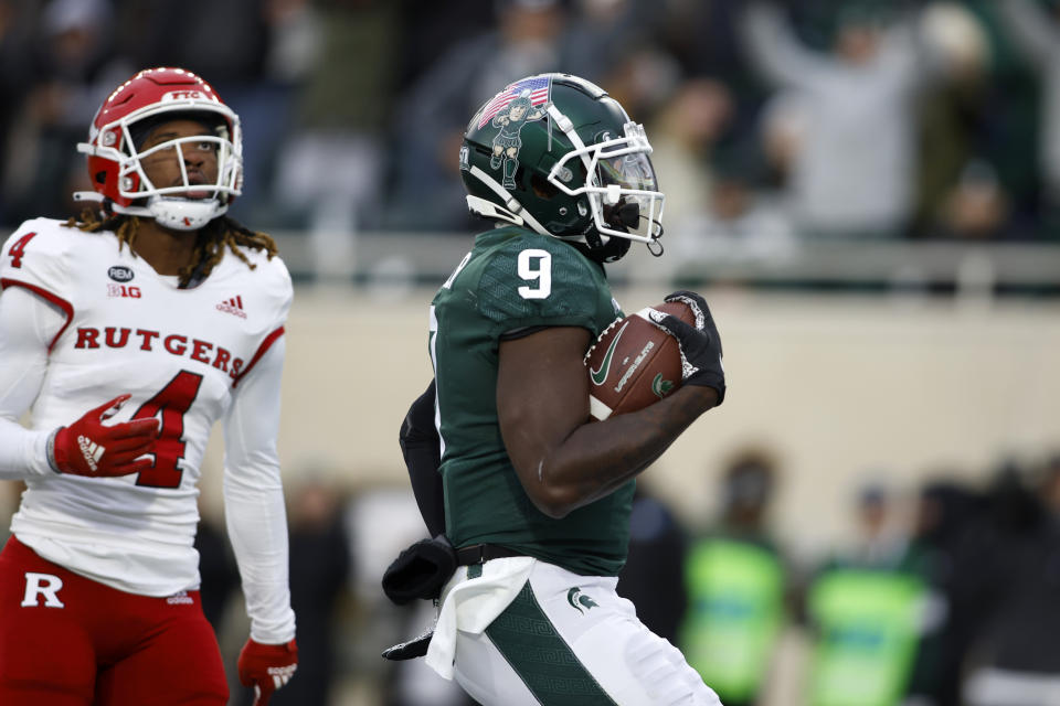 Michigan State's Daniel Barker, right, scores on a pass reception against Rutgers' Desmond Igbinosun (4) during the first half of an NCAA college football game, Saturday, Nov. 12, 2022, in East Lansing, Mich. (AP Photo/Al Goldis)
