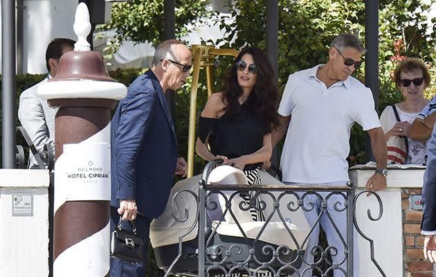 George carried one baby capsule while Amal carried the other. Source: SPLASH