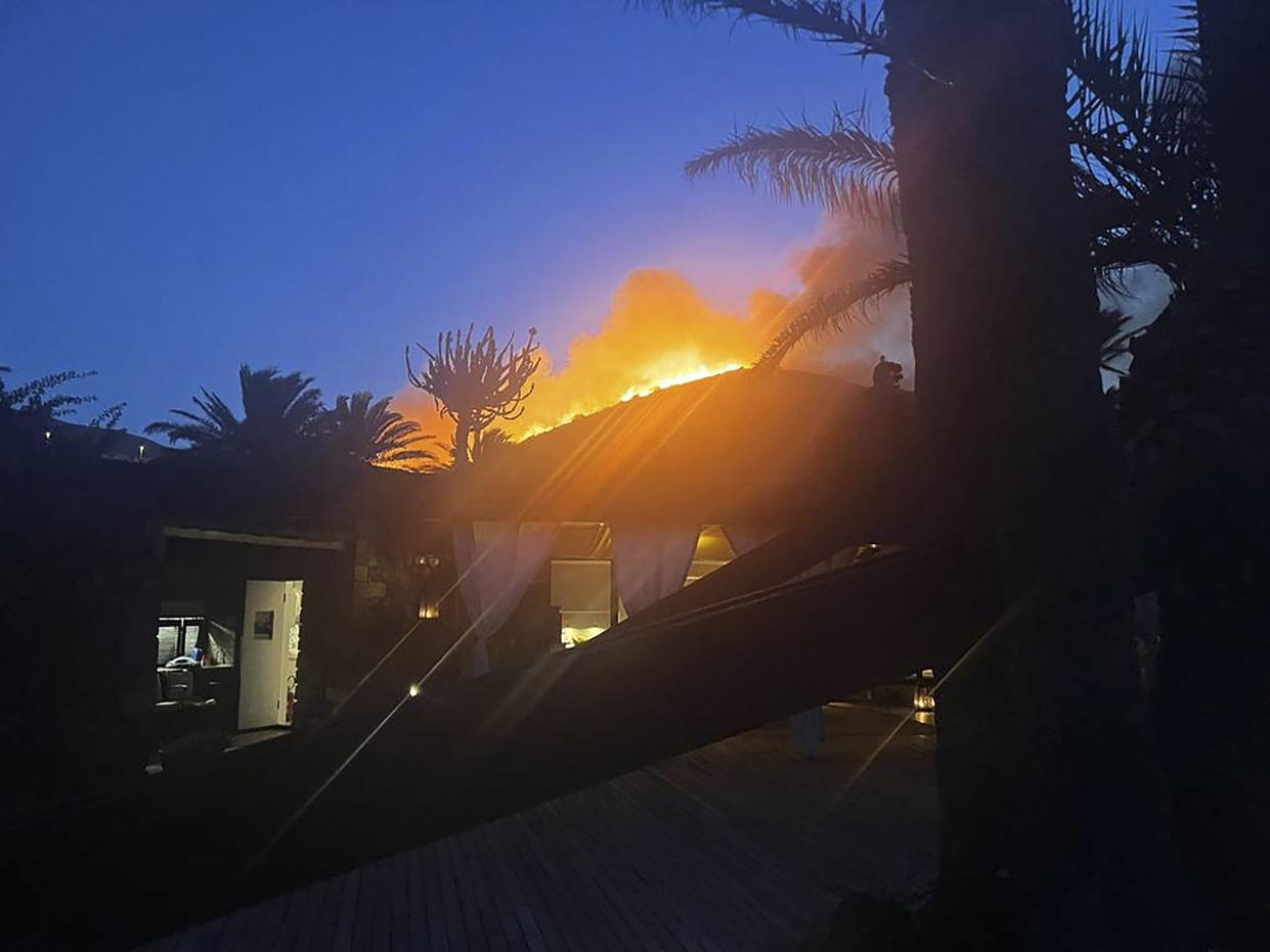 Flames burn beyond fashion designer Giorgio Armani's villa on the Sicilian island of Pantelleria, Wednesday, Aug. 17, 2022.