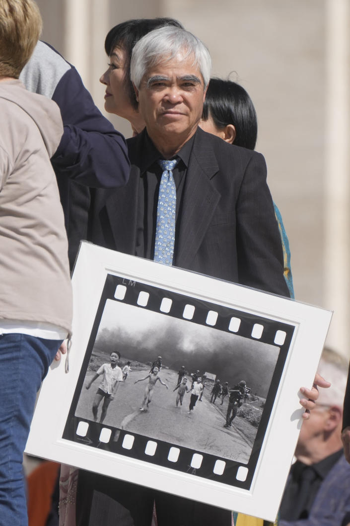 Pulitzer Prize-winning photographer Nick Ut holds the" Napalm Girl", his Pulitzer Prize winning photo as he waits to meet with Pope Francis during the weekly general audience in St. Peter's Square at The Vatican, Wednesday, May 11, 2022. Ut and UNESCO Ambassador Kim Phuc are in Italy to promote the photo exhibition "From Hell to Hollywood" resuming Ut's 51 years of work at the Associated Press, including the 1973 Pulitzer-winning photo of Kim Phuc fleeing her village after it was accidentally hit by napalm bombs dropped by South Vietnamese forces. (AP Photo/Gregorio Borgia)