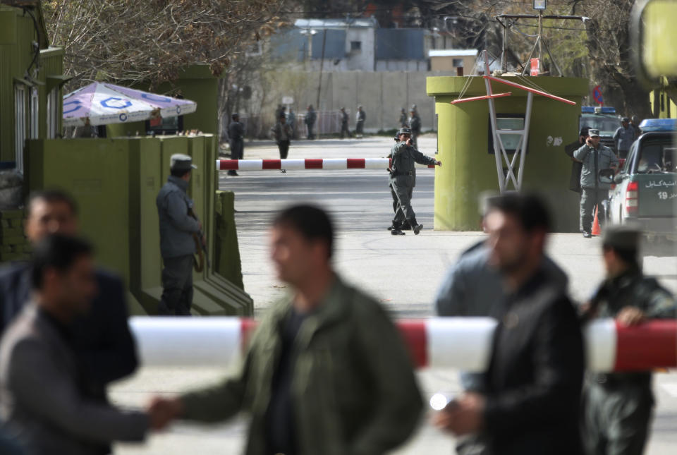 Afghan police arrive to the main gate leading to the Interior Ministry after a suicide bomber wearing a military uniform struck the entrance gate of the Interior Ministry compound in Kabul, Afghanistan, Wednesday, April 2, 2014. Ministry of Interior spokesman Sediq Sediqqi said the bomber, who was wearing a military uniform to evade security checks, reached the entrance of the heavily fortified ministry compound before detonating his explosives. (AP Photo/Massoud Hossaini)