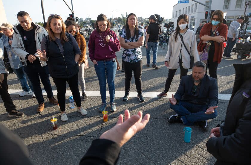 A group of people forming a prayer circle in the street