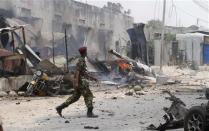 A policeman walks at the scene of an explosion near the entrance of the airport in Somalia's capital Mogadishu February 13, 2014. REUTERS/Feisal Omar