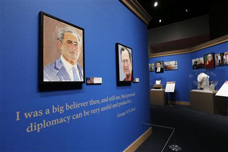 A self-portrait of former U.S. President George W. Bush and his father, former U.S. President George H.W. Bush, greet visitors at "The Art of Leadership: A President's Personal Diplomacy" exhibit at the Bush Presidential Library and Museum in Dallas, Texas April 4, 2014. REUTERS/Brandon Wade