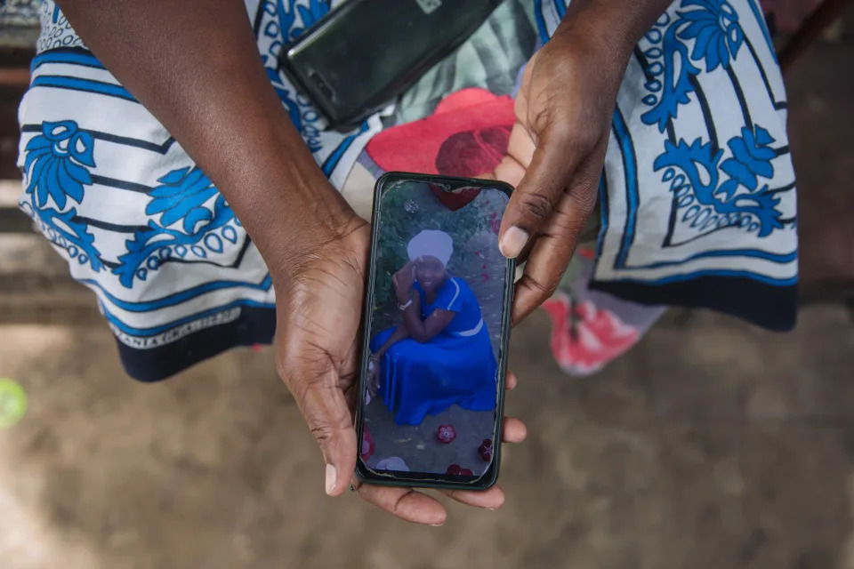 Priscilla Riziki shows a photo of her 25-year-old daughter, now missing along with her three children, who was a follower of apocalyptic preacher Paul Nthenge Mackenzie, in Malindi, Kenya, May 3, 2023. (Sarah Waiswa/The New York Times)