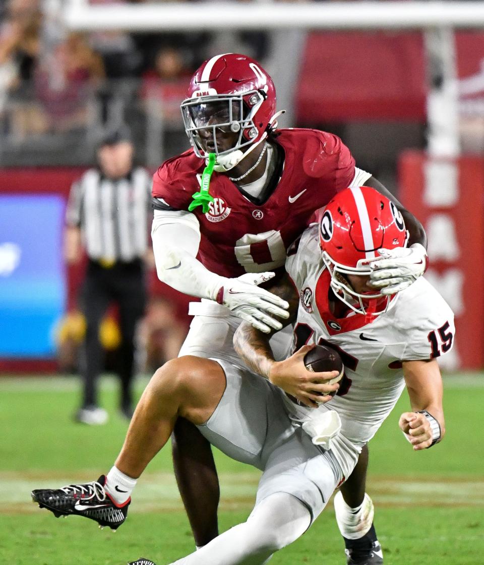 Sep 28, 2024; Tuscaloosa, Alabama, USA; Alabama Crimson Tide linebacker Deontae Lawson (0) sacks Georgia Bulldogs quarterback Carson Beck (15) for a loss at Bryant-Denny Stadium. Alabama defeated Georgia 41-34. Mandatory Credit: Gary Cosby Jr.-Imagn Images