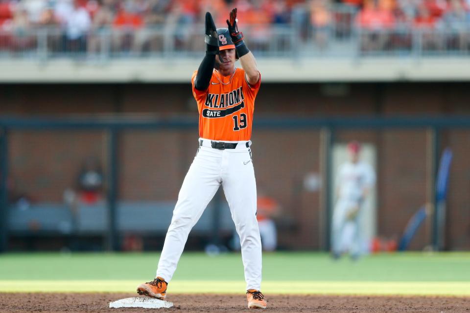 Oklahoma St. infielder Marcus Brown (19) claps towards fans after reaching second base during a NCAA Regional baseball championship game between Oklahoma St. and Arkansas at O'Brate Stadium in Stillwater, Okla. on Monday, June 6, 2022.(Ian Maule/Tulsa World via AP)