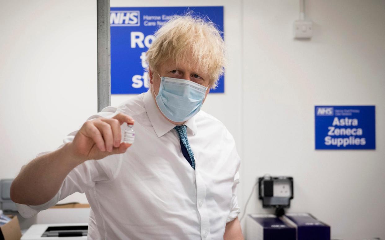 Boris Johnson holds a vial of the Oxford AstraZeneca COVID-19 vaccine - Pool PA