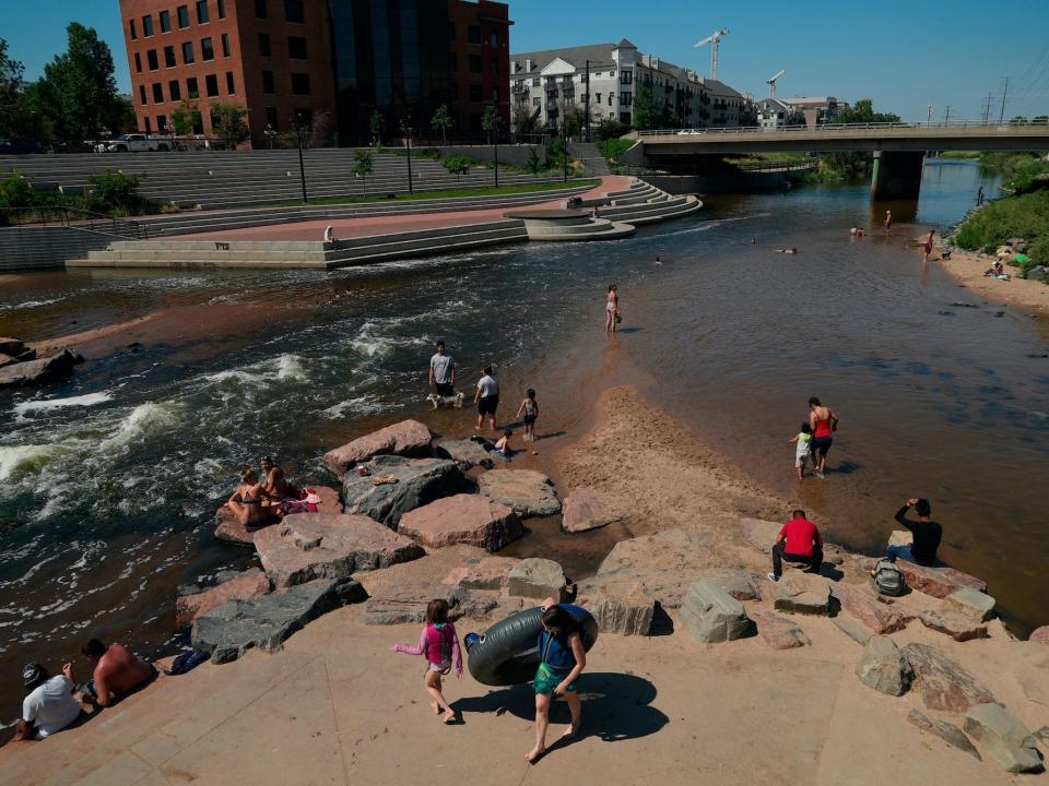 People in the water the confluence of the South Platte River and Cherry Creek in Denver.