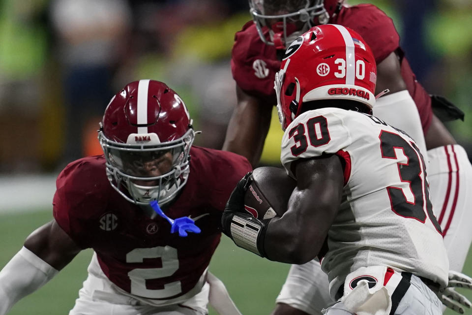 Georgia running back Daijun Edwards (30) runs the ball against Alabama defensive back Caleb Downs (2) during the first half of the Southeastern Conference championship NCAA college football game in Atlanta, Saturday, Dec. 2, 2023. (AP Photo/Mike Stewart)