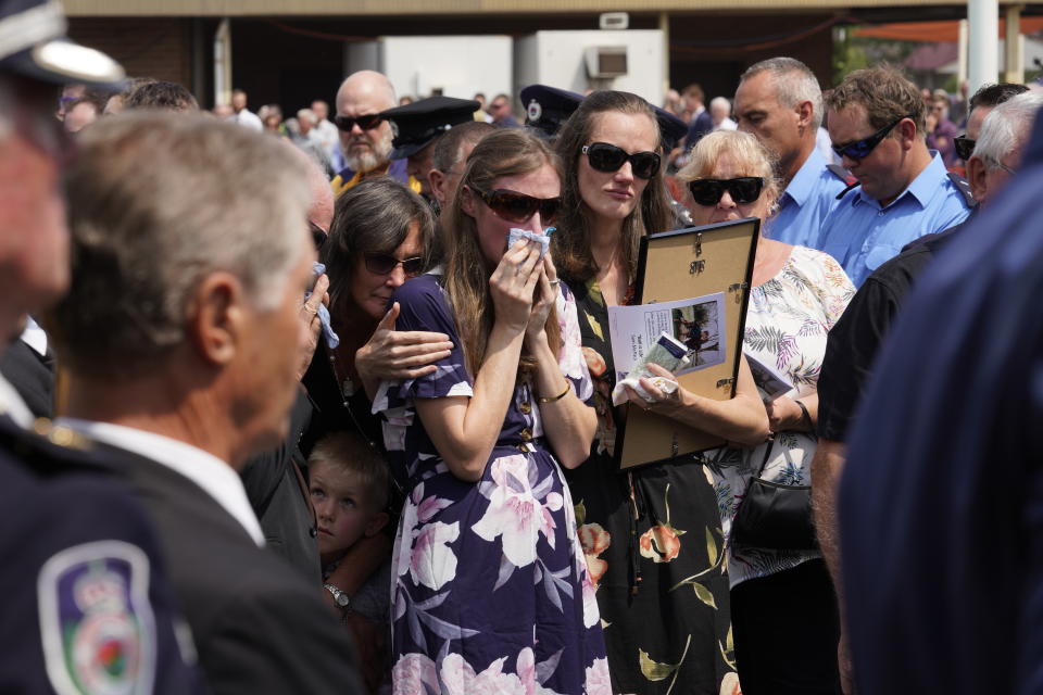 Samuel McPaul's widow Megan wipes away tears as she watches the casket being loaded into the hearse.