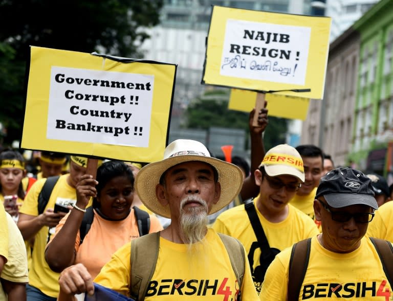 Protestors hold placards demanding Prime Minister Najib Razak's resignation during an anti-government rally in Kuala Lumpur on August 29, 2015