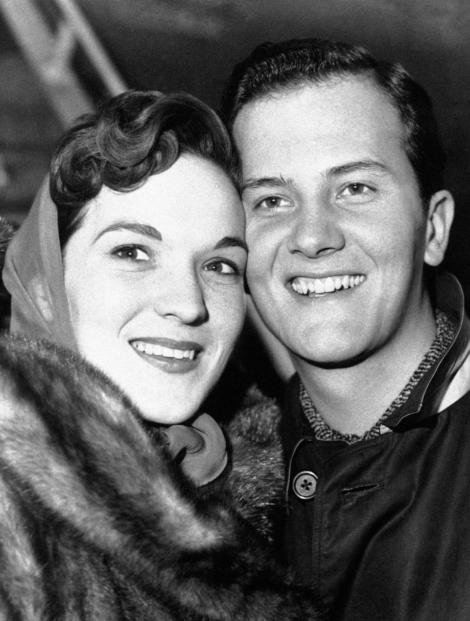 FILE - In this April 4, 1958 file photo, American singer Pat Boone and his wife Shirley are pictured at the London airport after their arrival from New York. Shirley Boone, the longtime wife of singer Pat Boone as well as a philanthropist, has died at age 84. Milt Suchin, Pat Boone's manager, says in a statement that Shirley Boone passed away on Friday, Jan. 11, 2019, surrounded by her four daughters, who sang to her. (AP Photo/File)