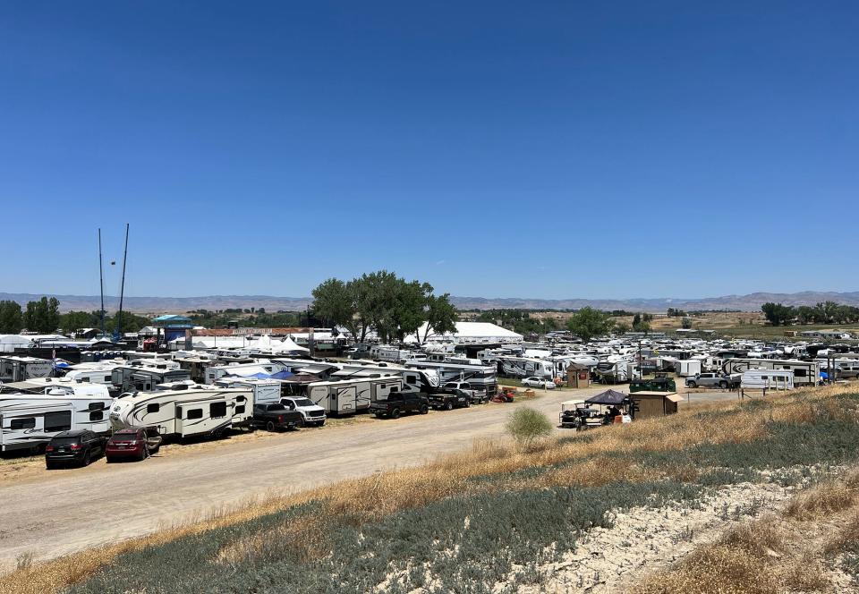 a view of campers parked in a lot of dirt and grass