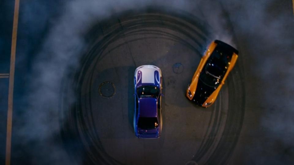 One car drifting in a circle around another car in Tokyo Drift