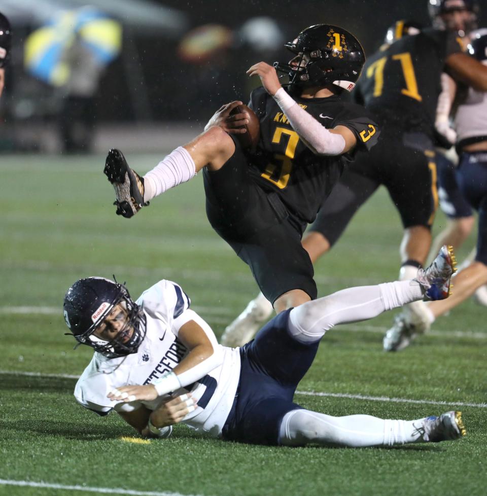 McQuaid's John Harding hops over a McQuaid player for attempting to stop him during the Section V championship title at SUNY Brockport on Nov. 11, 2022. Harding got several more yards before being stopped.