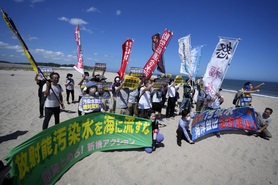 People protest at a beach toward the Fukushima Daiichi nuclear power plant, damaged by a massive March 11, 2011, earthquake and tsunami, in Namie town, northeastern Japan, Thursday, Aug. 24, 2023. The operator of the tsunami-wrecked Fukushima Daiichi nuclear power plant says it began releasing its first batch of treated radioactive water into the Pacific Ocean on Thursday — a controversial step, but a milestone for Japan’s battle with the growing radioactive water stockpile. The banner, seen at right, reads: Oppose to the release of the treated radioactive water into the ocean. (AP Photo/Eugene Hoshiko)