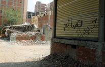 A general view of a graffiti reading in Arabic "reconciliation" next to a destructed building in Banha