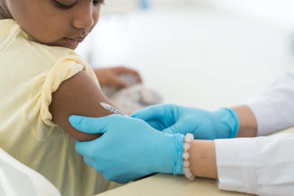 Close up vaccination of a little boy on his arm in a doctor's office.