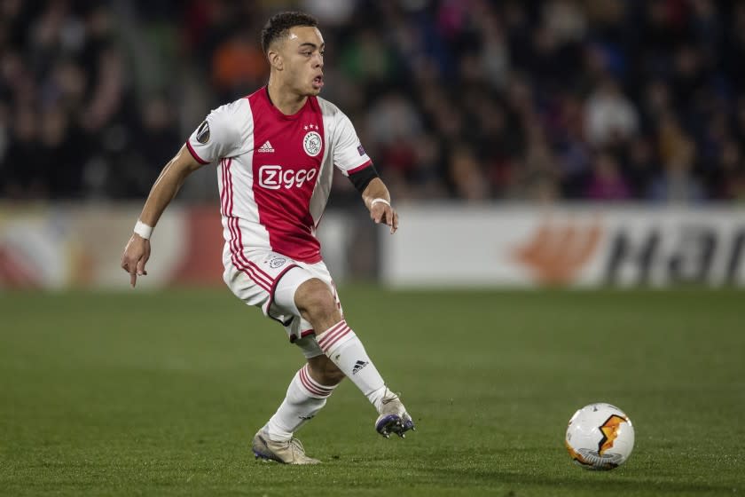 FILE - In this Feb. 20, 2020 file photo, Ajax's Sergino Dest kicks the ball during an Europa League soccer match against Getafe in Getafe, Spain. Champions League champion Bayern Munich has signed American right back Sergino Dest from Ajax Amsterdam. The Bundesliga club says the 19-year-old Dest, who has a Surinamese-American father and Dutch mother, has signed a deal. (AP Photo/Bernat Armangue)