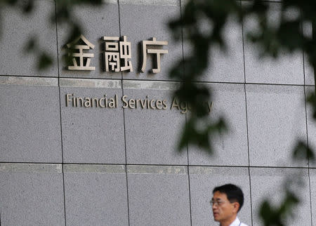 A man walks past a sign of Japan's Financial Services Agency in Tokyo August 7, 2014. REUTERS/Toru Hanai/File Photo